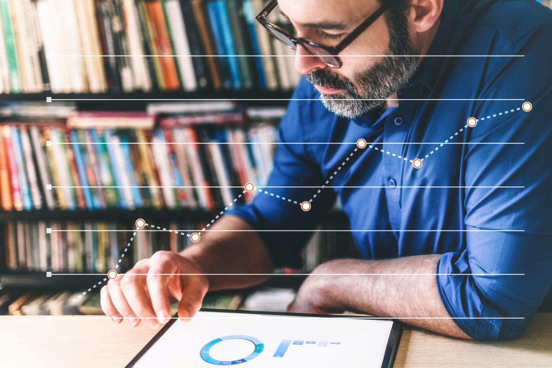 bearded business man checking checking business stats at digital tablet